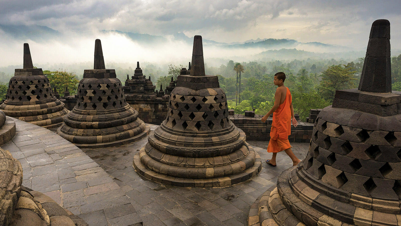 Un moine bouddhiste marche entre les stupas du monument de Borobudur à Java.