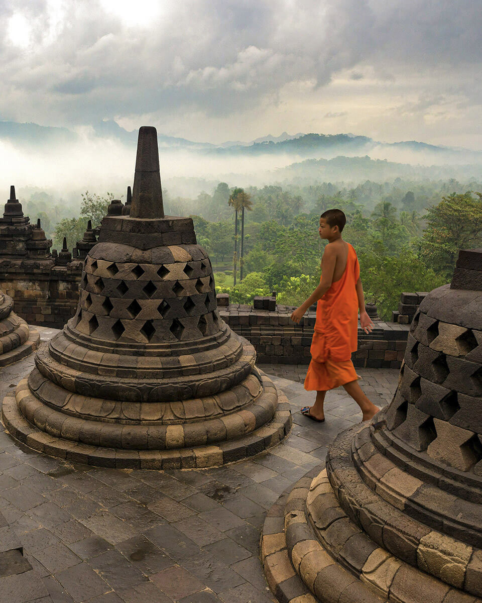 Un moine bouddhiste marche entre les stupas du monument de Borobudur à Java.